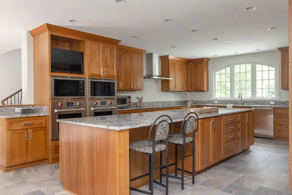 Design-build remodeling Madison WI: historic home kitchen with cherry cabinets, granite island, double wall ovens and an arched window