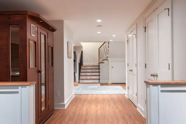 Hallway in a historic Madison, WI whole-home remodel with additions, with hardwood floors, white millwork and a refinished staircase