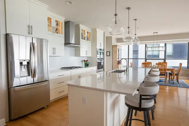Condo kitchen and dining remodel in Madison, WI with a French-door refrigerator, white quartz island and swivel counter stools